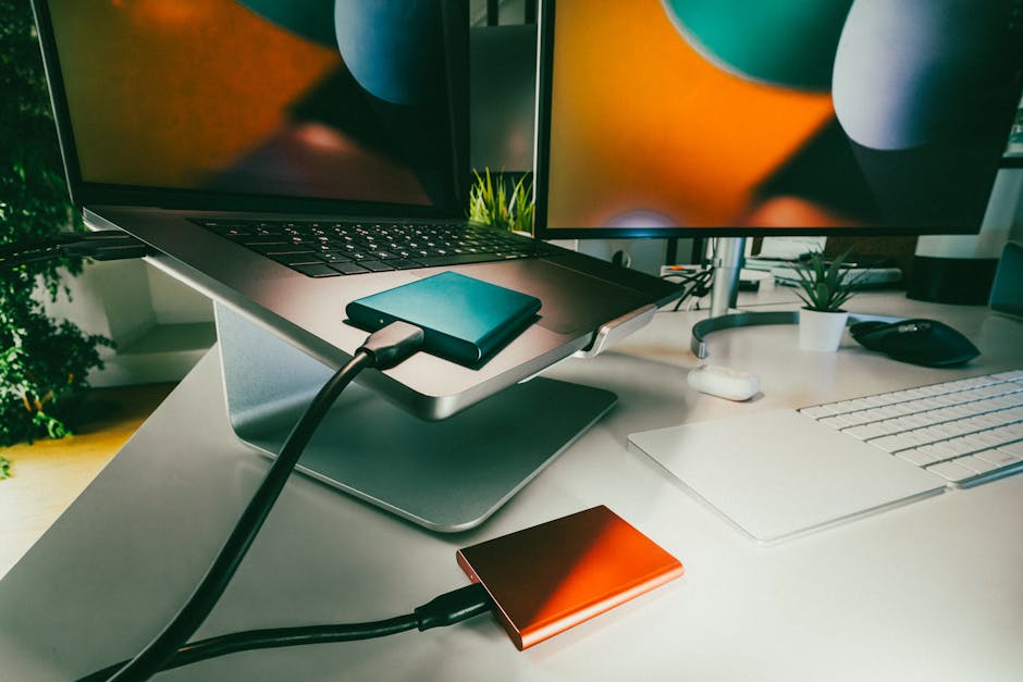 External hard drives and laptop on a tidy home-office desk representing personal data backup