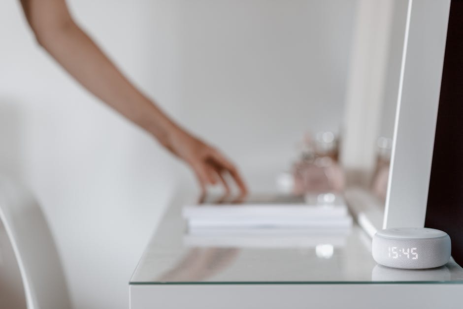 A spread of smart-home devices — speaker, smart plug, light bulb, tablet — laid out on a wooden desk