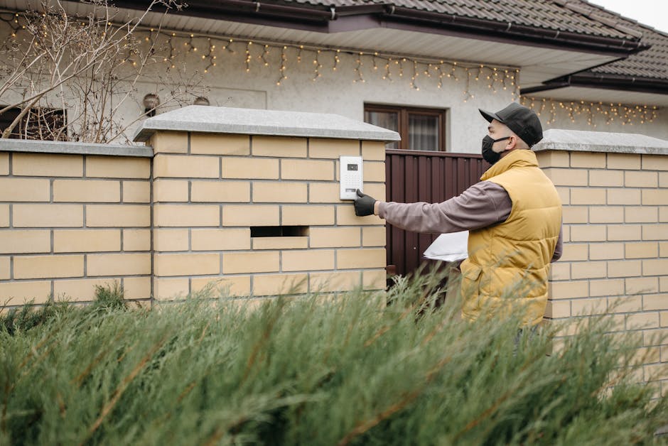 Hand pressing a video doorbell button on a home entrance
