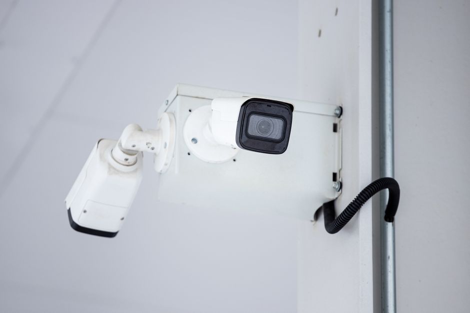 Wall-mounted outdoor security camera watching over a property