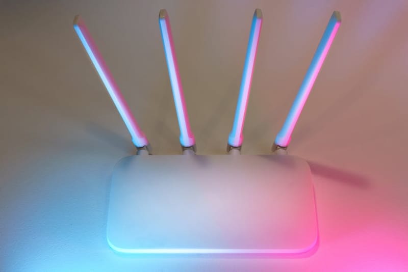 A white home Wi-Fi router with four antennas